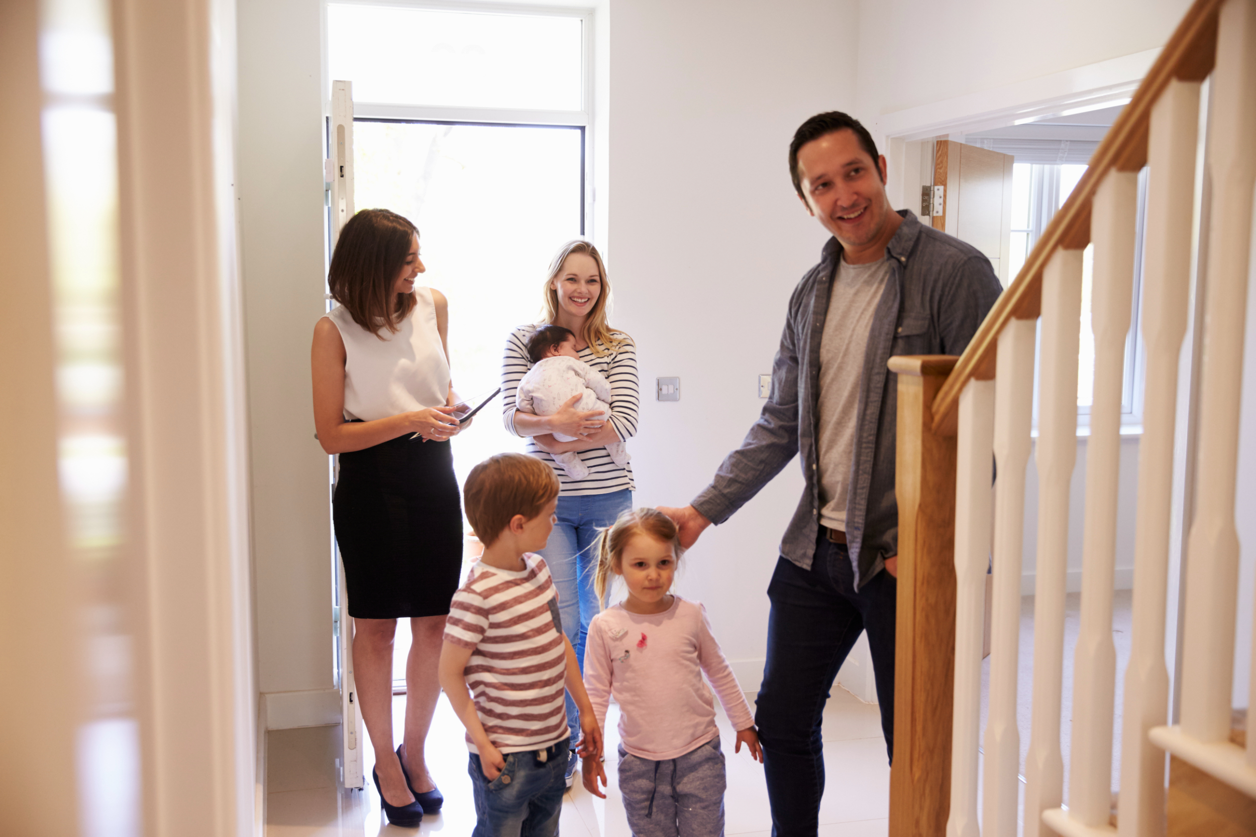 A family touring a new home with a realtor