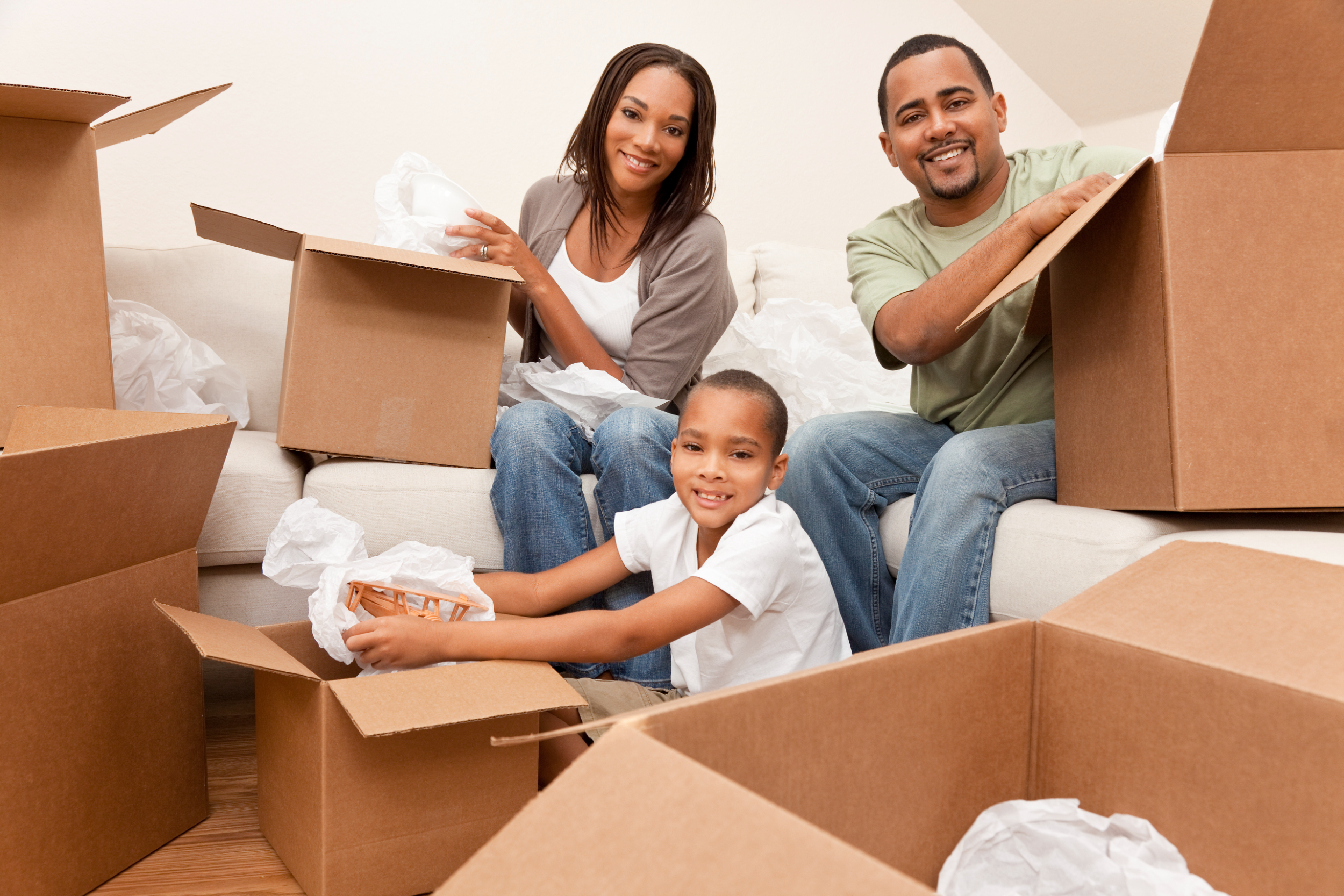 A young family smiling with moving boxes